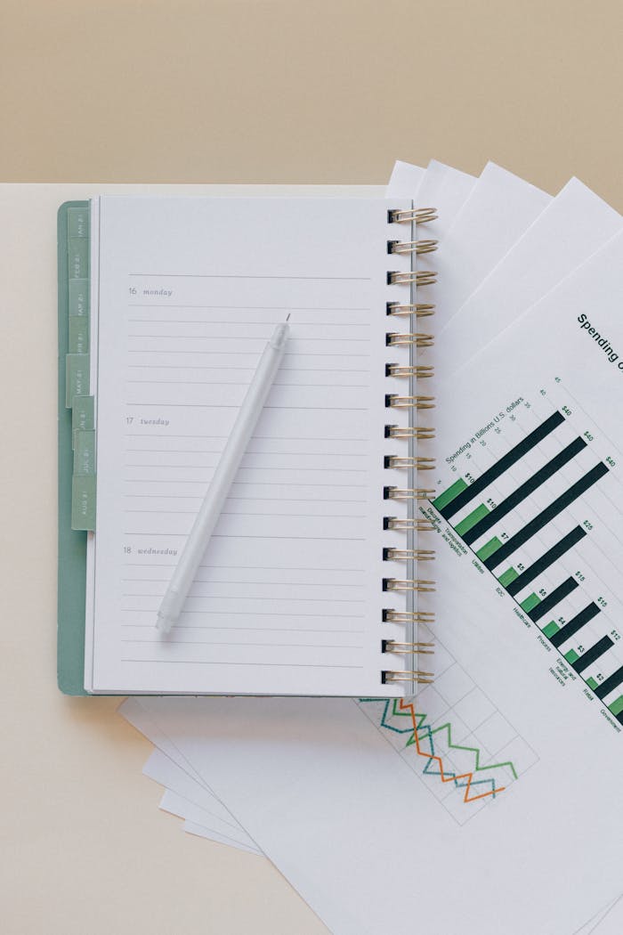 An open planner with a pen on top of graph sheets, perfect for planning and organization.